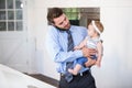 Businessman talking on cellphone while carrying daughter Royalty Free Stock Photo