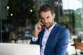 Businessman talking on his cellphone at a sidewalk cafe table Royalty Free Stock Photo