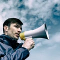 Businessman talking in a megaphone against the sky. Royalty Free Stock Photo