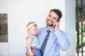 Businessman talking on mobile phone while carrying daughter Royalty Free Stock Photo