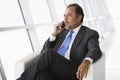 Businessman talking on mobile phone in lobby Royalty Free Stock Photo