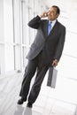 Businessman talking on mobile phone in lobby Royalty Free Stock Photo