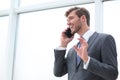 Businessman talking on a mobile phone standing near the office window Royalty Free Stock Photo