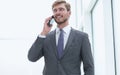 Businessman talking on a mobile phone standing near the office window Royalty Free Stock Photo