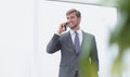 Businessman talking on a mobile phone standing near the office window Royalty Free Stock Photo