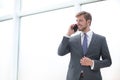 Businessman talking on a mobile phone standing near the office window Royalty Free Stock Photo