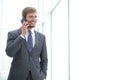 Businessman talking on a mobile phone standing near the office window Royalty Free Stock Photo