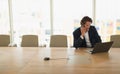 Businessman talking on mobile phone while using laptop in the conference room Royalty Free Stock Photo
