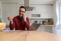 Businessman talking over mobile phone and laughing cheerfully while sitting at desk in home office Royalty Free Stock Photo