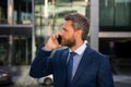 Businessman talking on phone. Portrait of cheerful Business man office worker talking on mobile phone while standing