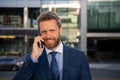 Businessman talking on phone. Portrait of cheerful Business man office worker talking on mobile phone while standing