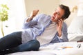 Businessman talking on the phone screaming with joy on bed Royalty Free Stock Photo