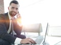 Foreground businessman talking on a smartphone