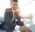 Foreground businessman talking on a smartphone