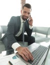 Foreground businessman talking on a smartphone