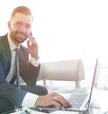 Foreground businessman talking on a smartphone