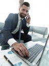 Foreground businessman talking on a smartphone