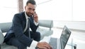 Foreground businessman talking on a smartphone