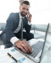 Foreground businessman talking on a smartphone