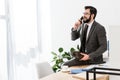 businessman talking by stationary telephone in office and sitting Royalty Free Stock Photo