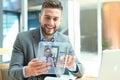 Businessman talking to his colleagues in video conference. Business team working from office using transparent tablet Royalty Free Stock Photo