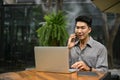 A businessman talks on the phone while sitting in a coffee shop with his laptop Royalty Free Stock Photo