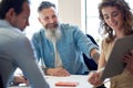 businessman team leader meeting with colleagues in office with business woman using tablet computer presenting ideas for