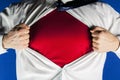 Businessman tearing off his suit on blue background, man pushes shirt with red t-shirt. Superhero Royalty Free Stock Photo