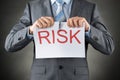 Businessman tearing the word risk on paper