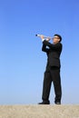 Businessman with telescope looking forward