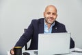 Businessman teleworking with a laptop having a coffee