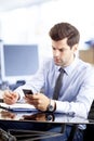 Businessman text messaging on mobile in office Royalty Free Stock Photo