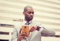 Businessman texting on mobile phone and looking at his watch Royalty Free Stock Photo
