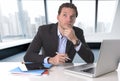 Businessman thinking at computer laptop desk looking reflexive a