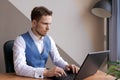 Businessman thinking about online project, looking at laptop at workplace