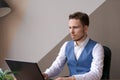 Businessman thinking about online project, looking at laptop at workplace