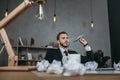 Businessman throwing paper airplane while sitting at workplace Royalty Free Stock Photo