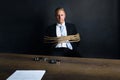 Businessman tied with rope sitting in front of table