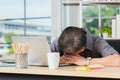 Businessman tired overworked he sleeping over a laptop computer Royalty Free Stock Photo