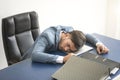 Businessman tired overworked sleeping over a laptop in office Royalty Free Stock Photo