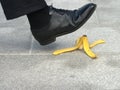 Businessman stepping on banana skin, work accident, banana peel in street Royalty Free Stock Photo