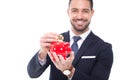 Businessman with toothy smile drop golden bitcoin into piggy ban