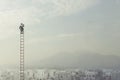 Businessman at the top of a long ladder observes the city with his binoculars