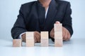 Businessman touches the woodblocks placed on the table