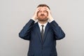 Businessman touching head with frown disappointed sickly emotional face isolated studio background.