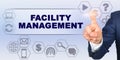 Businessman touching virtual screen with his finger. Screen caption - FACILITY MANAGEMENT