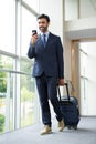 Businessman with trolley bag using mobile phone Royalty Free Stock Photo