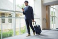 Businessman with trolley bag using mobile phone Royalty Free Stock Photo