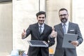 Businessman trumps up and holding power solar cell and laptops computer with smile confident on site new project power