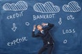 Businessman trying to cover head by his hands surrounded with clouds and words Royalty Free Stock Photo